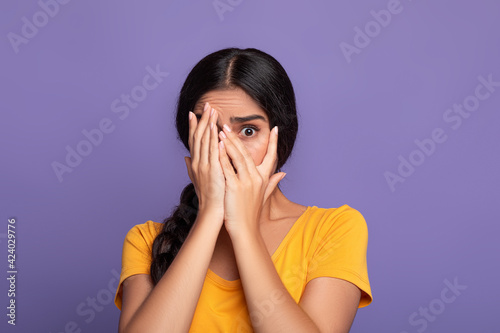 Omg. Portrait of shocked young indian woman covering one eye