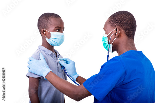 a young male doctor examining a little boy with a stethoscope.