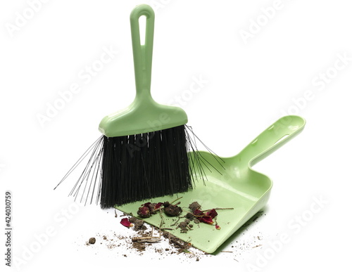 Green dustpan with bristle, broom sweeper with dirt isolated on white background, top view photo