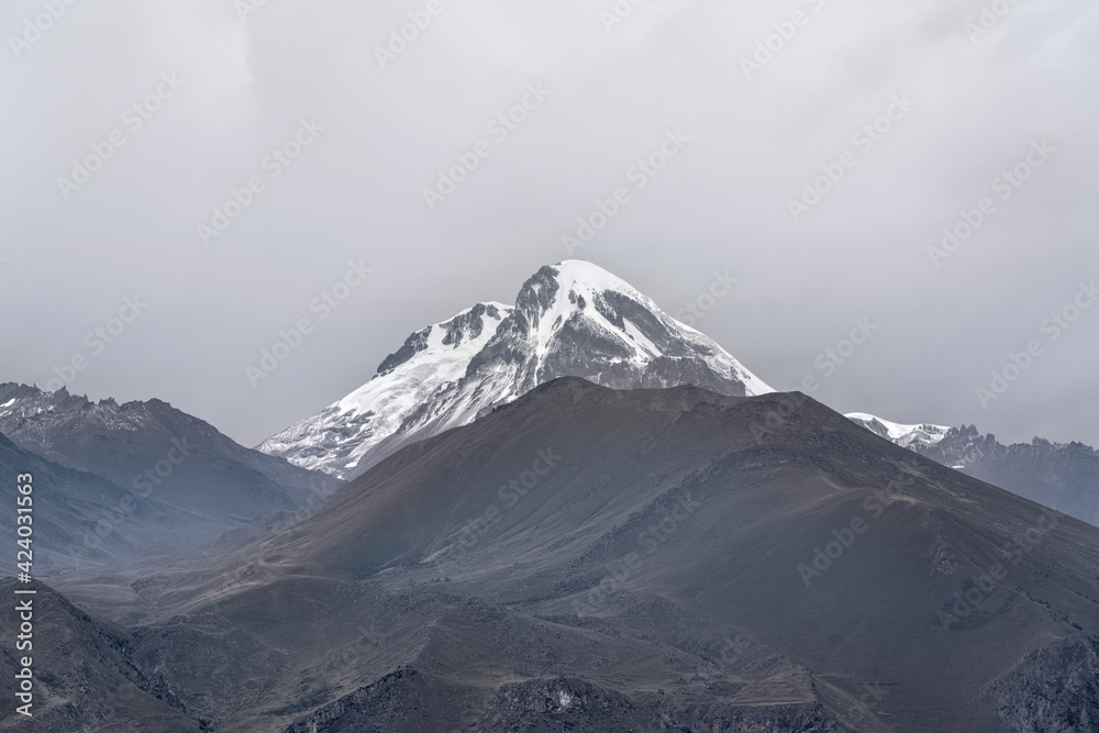 Snow-capped Mount Kazbeg against the background of a cloudy sky Snow-capped Mount Kazbeg against the background of a cloudy sky
