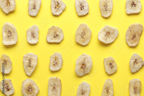 Композиция с кусочками сладкого сушеного банана на желтом фоне. Сухофрукты как полезная закуска