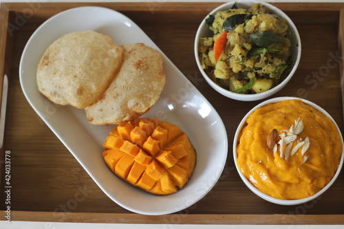 Puri served with mango pulp and potato masala. Locally known as puri masala and aamras. photo