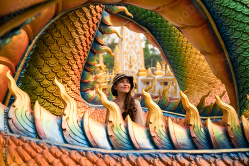 Happy asian woman smiling in colorful serpent statue at Wat Phra That Nong Bua temple photo