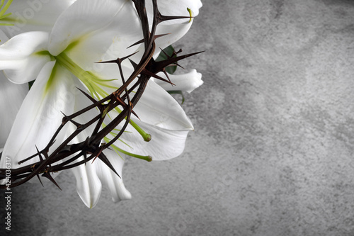 Good Friday, Passion of Jesus Christ. Crown of thorns, nails and white lily on grey background. Christian Easter holiday. photo