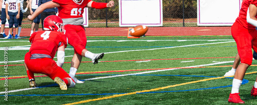 Field goal kicker kicking the ball during a football game