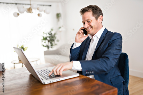 businessman working on laptop online sitting at kitchen table