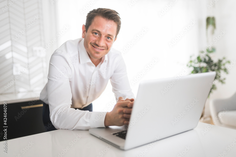surprised business man working on laptop online sitting at kitchen table