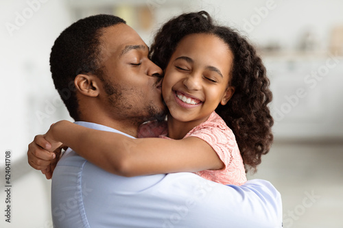 Loving black dad kissing his beautiful little daughter