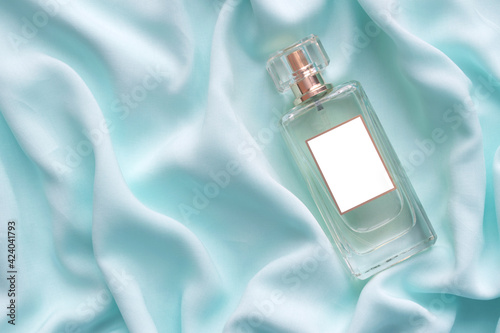 Bottle of perfume on a blue silk cloth