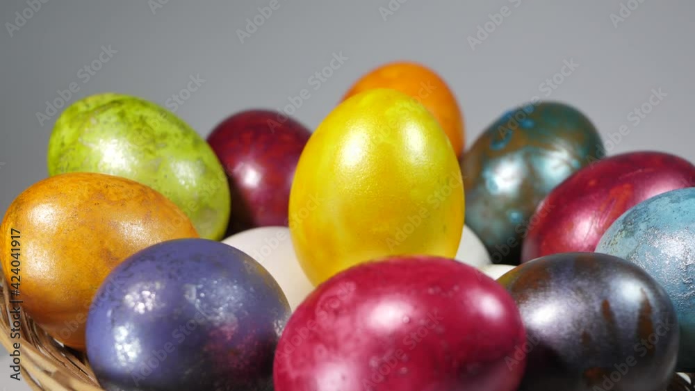 Colored eggs rotate in a basket. Easter eggs in all colors Colored eggs rotate in a basket. Easter eggs in all colors