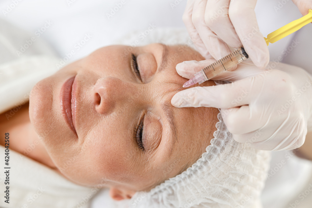 Close up makes mesotherapy injections to a senior woman. Treatment of a woman by a beautician for tightening and smoothing wrinkles on the face skin Close up makes mesotherapy injections to a senior woman. Treatment of a woman by a beautician for tightening and smoothing wrinkles on the face skin