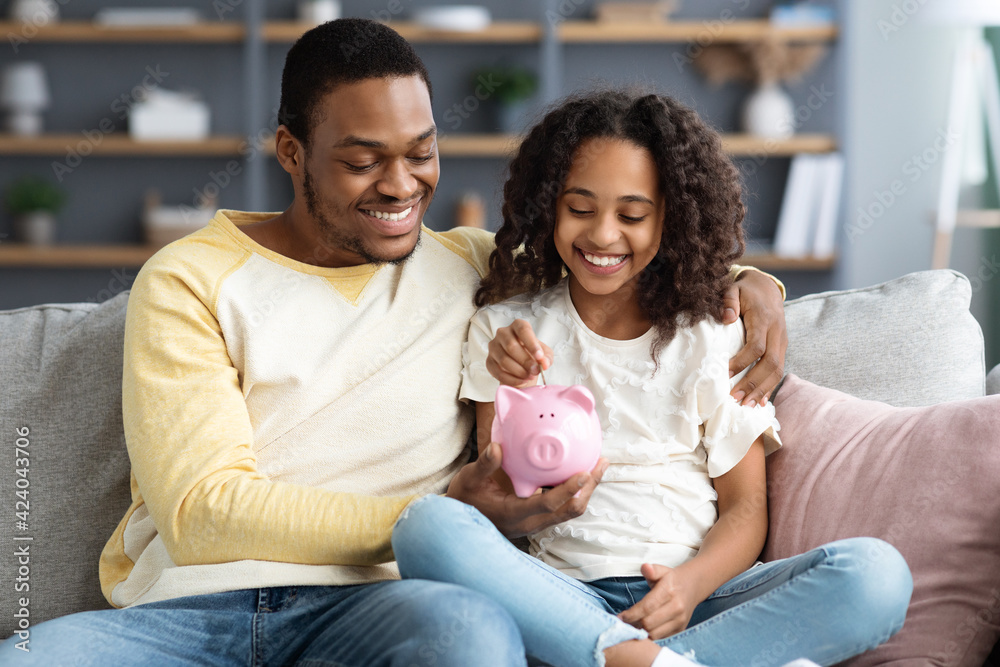 Ταπετσαρία Black girl and father putting coin into piggy bank