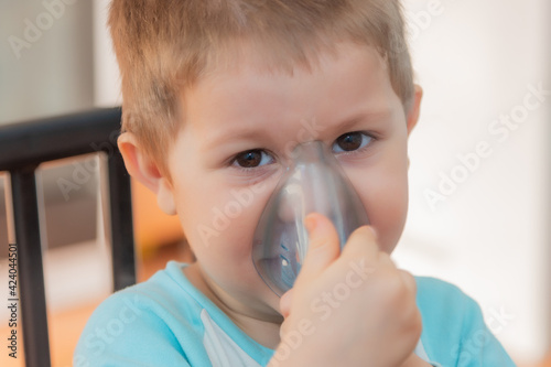 Foto Little boy using nebulizer during inhaling therapy