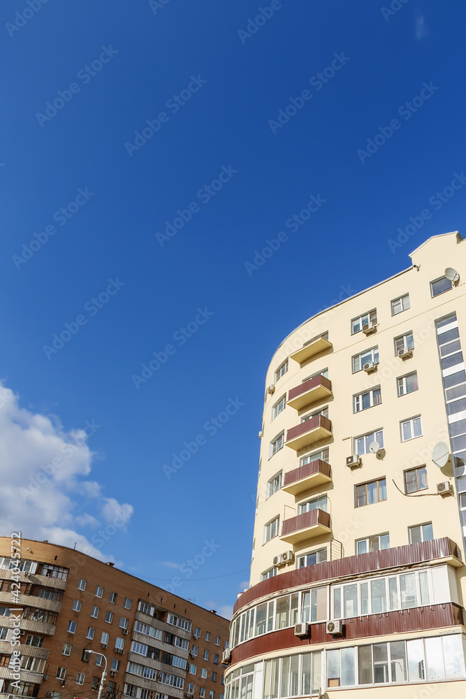 Houses on a blue sky background with white clouds of early spring.