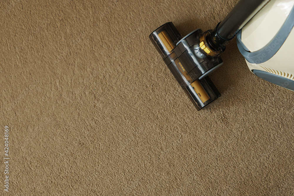 Vacuum cleane nozzle on the carpet. Space for text.Close-up