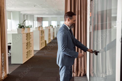 Happy adult caucasian man is working in a modern office