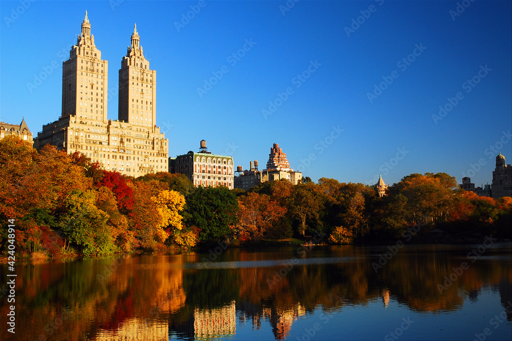 The luxury apartment buildings of Manhattan rise over the autumn foliage of Central Park