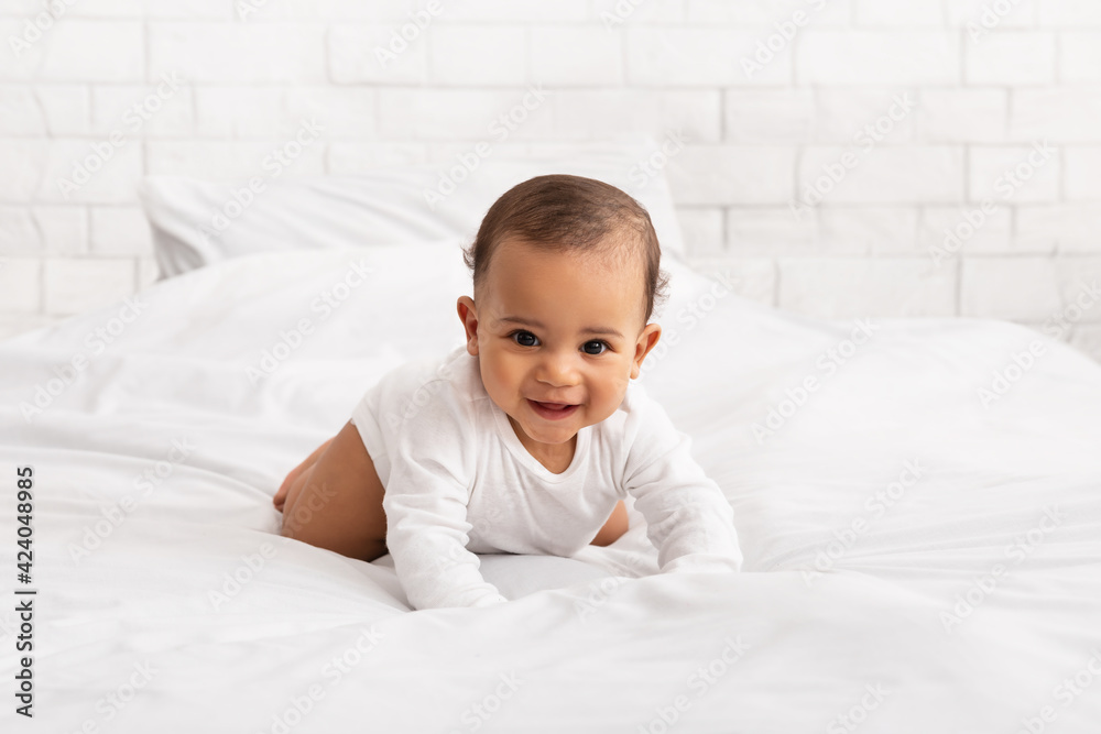 Black Baby Crawling On Bed Smiling To Camera In Bedroom