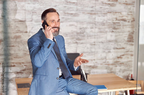 Happy adult caucasian man is working in a modern office