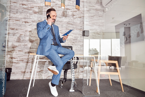 Happy adult caucasian man is working in a modern office