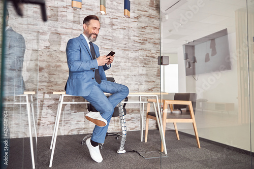 Happy adult caucasian man is working in a modern office