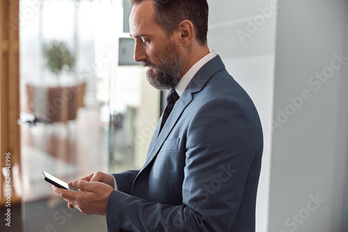 Happy adult caucasian man is working in a modern office