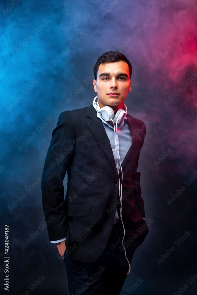 Portrait of man with headphones on dark background with smoke. Looking up. Studio shoot Portrait of man with headphones on dark background with smoke. Looking up. Studio shoot