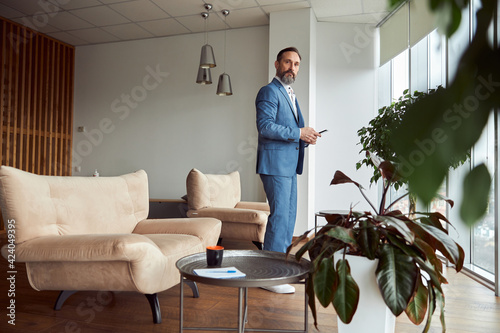 Happy adult caucasian man is working in a modern office