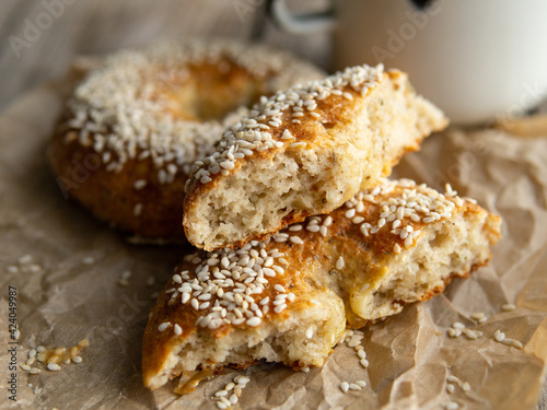 Fresh cheese donuts with sesame seeds on a wood background with metal white cup of coffee. Heathy food, diet, breakfast, lunch. Top view with copy space. retro, vitage.