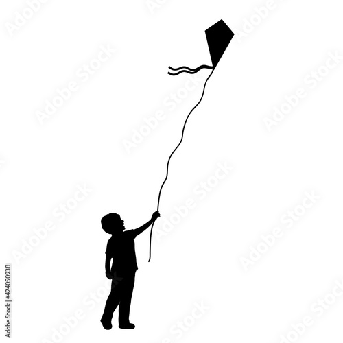 Silhouette little boy flying kite.