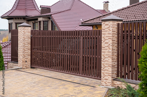 Wallpaper Mural metal front gates with elements of forged parts with stone pillars, fencing of private territory Torontodigital.ca