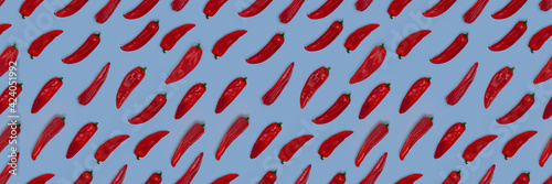 Abstract seamless pattern of fresh red long sweet pointed peppers on color background.