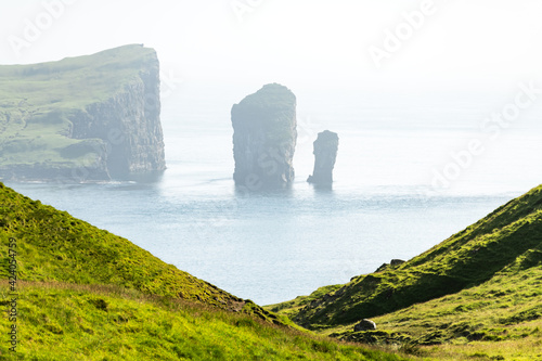 Dramatic view on Drangarnir and Tindholmur sea stacks in Atlantic ocean from Vagar island, Faroe Islands. Landscape photography