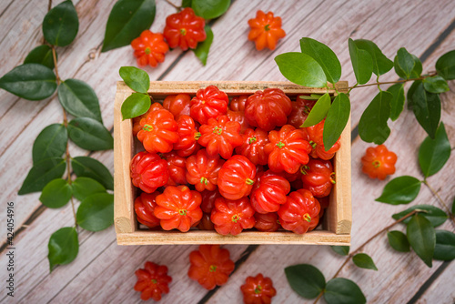 Suriname cherries in a small wooden box on a wooden surface. photo