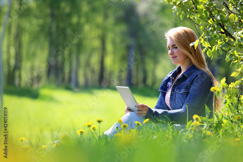 Young woman using tablet in park