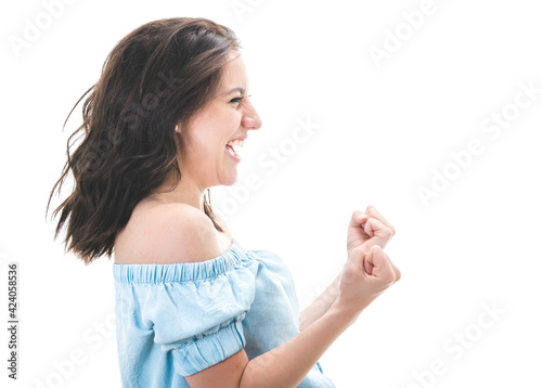 Profile of excited young woman with closed eyes and clenched fists, isolated on white background. Yes concept. Good news. Pretty girl celebrates success