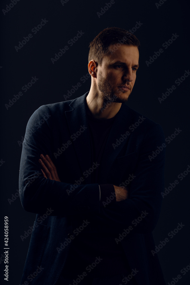 Business man portrait on dark background. Handsome young man weared suit in studio. Confident professional fashion male posing in studio.