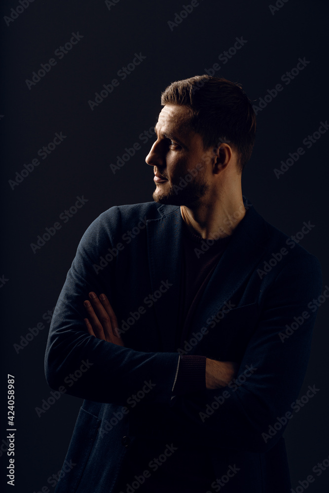 Business man portrait on dark background. Handsome young man weared suit in studio. Confident professional fashion male posing in studio.