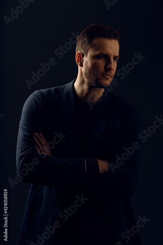 Business man portrait on dark background. Handsome young man weared suit in studio. Confident professional fashion male posing in studio.