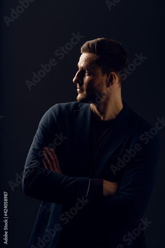 Business man portrait on dark background. Handsome young man weared suit in studio. Confident professional fashion male posing in studio. © Rabizo Anatolii