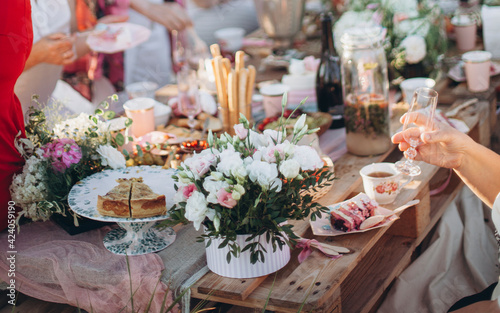 a bouquet of flowers on a table from pallets. celebrating with friends and family in a park or garden. outdoor picnic. festive boho wedding table