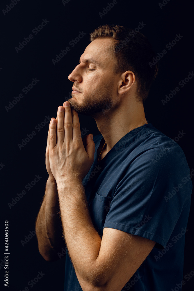 Man cover his face with his hands and thinks about life. Handsome man pray and believe in God. Orthodox Christian faith. Man cover his face with his hands and thinks about life. Handsome man pray and believe in God. Orthodox Christian faith.