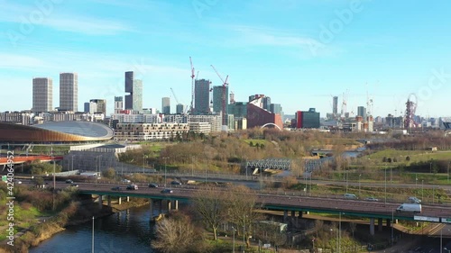 FLYING FORWARD OVER BRIDGES REVEALING A BEAUTIFUL CITY WITH TALL BUILDING DURING WINTER IN LONDON, STRATFORD photo