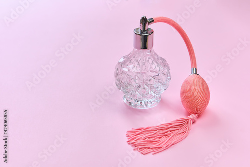 vintage perfume bottle with atomizer on pink background.
