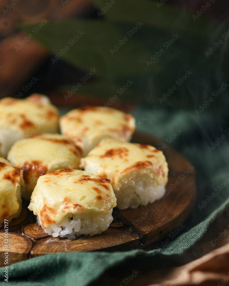 baked rolls with mozzarella and parmesan cheese cap on a wooden board decorated with bamboo leaves baked rolls with mozzarella and parmesan cheese cap on a wooden board decorated with bamboo leaves