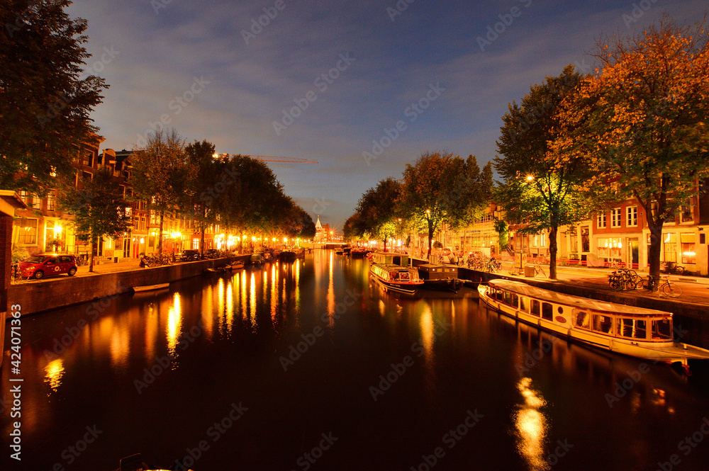 Channels in Amsterdam, the Netherlands illuminated at night with colorful lights. Night.