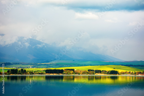 liptovska mara lake of slovakia. beautiful landscape in spring. reflection on the water surface. distant mountains in clouds