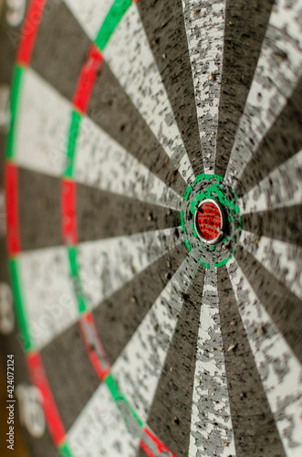 an old dartboard with close-up dart holes. the symbol is the path to the goal