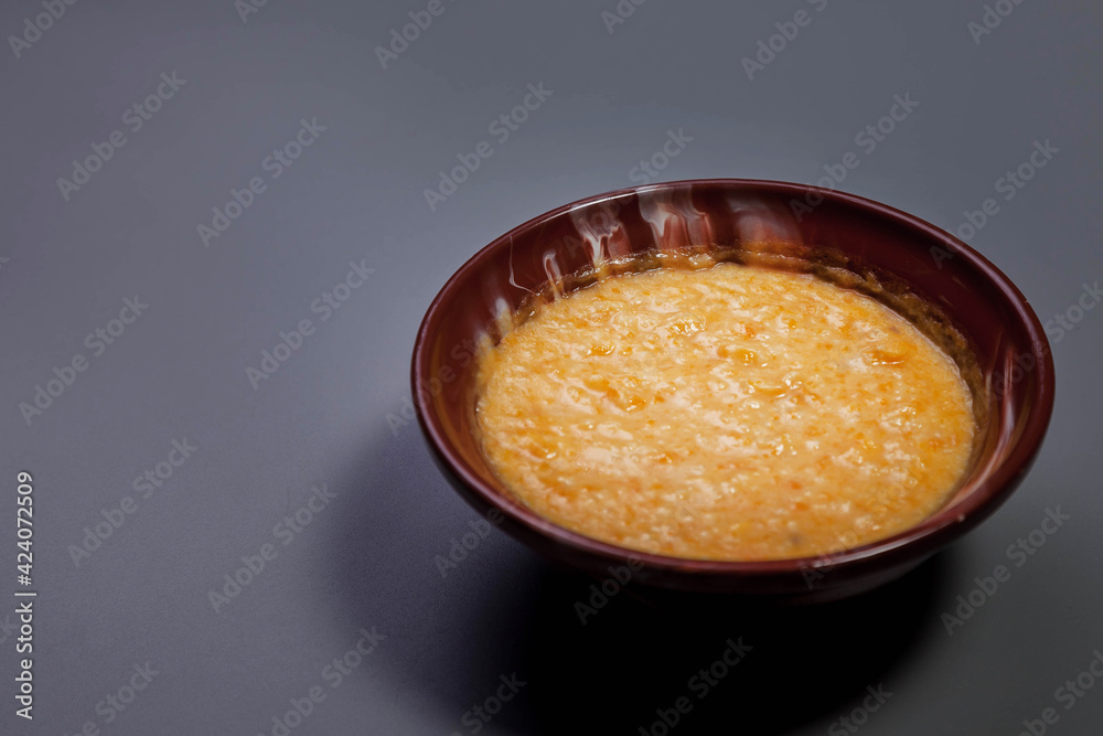 Wheat porridge with almond milk on dark grey color background. Traditional food health in brown plate in form heart with wheat porridge. Delicious healthy food diet. Copy space