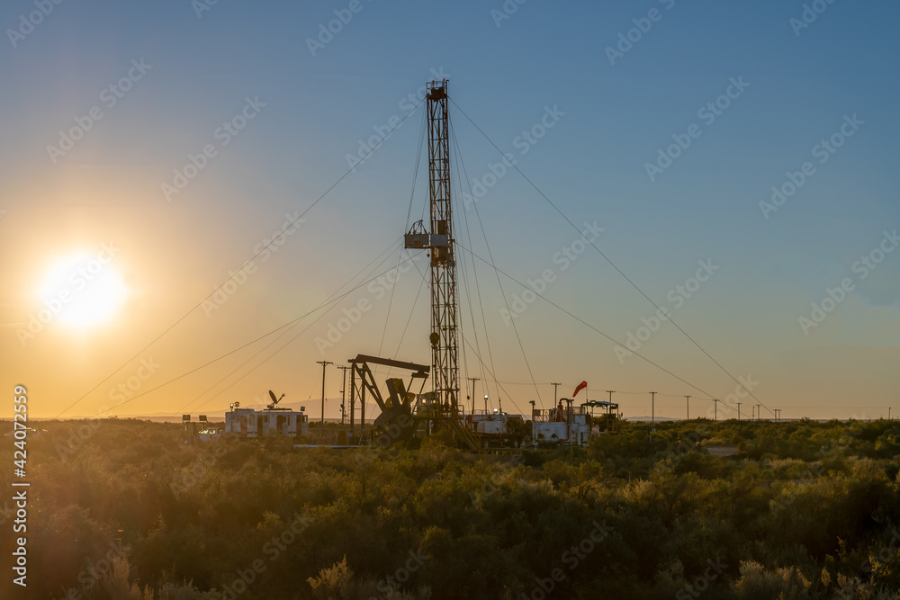pulling equipment in oil field at sunset